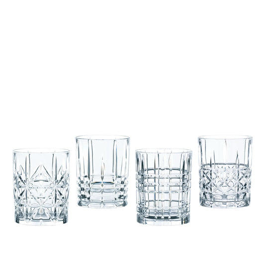 Four clear cut-crystal style rocks glasses with different geometric faceted patterns, arranged in a row on a plain white background.