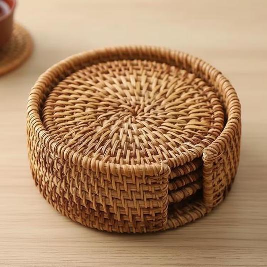 Set of woven rattan coasters stacked in a round basket on a wooden surface