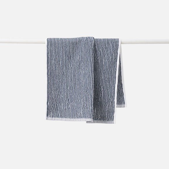 navystriped towel hanging on a white rack against a white background