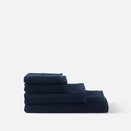 Stack of navy blue towels on a white background