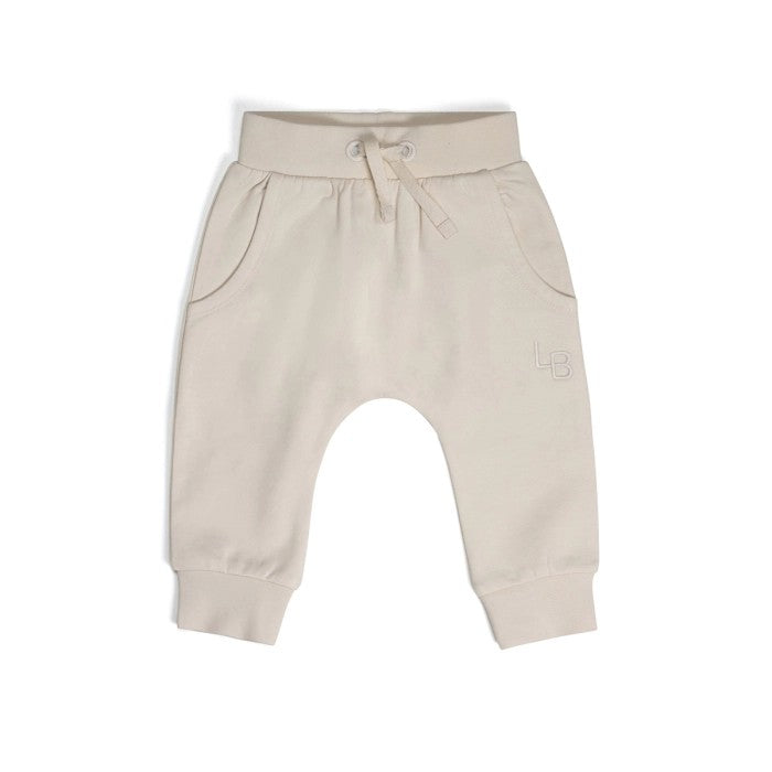 A pair of beige cotton fleece baby pants with a gentle stretch and a drawstring waistband.
