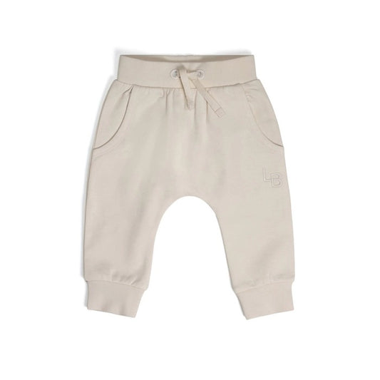 A pair of beige cotton fleece baby pants with a gentle stretch and a drawstring waistband.