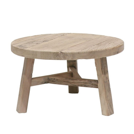 A round, natural wood coffee table with visible wood grain and slight imperfections, supported by a simple, solid wood leg construction.