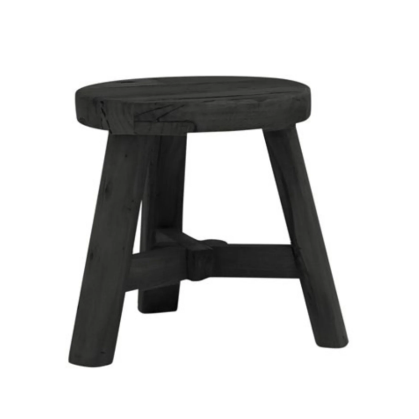 A rustic black wooden stool with a round seat and four angled legs connected by a central stretcher bar, shown on a plain white background.