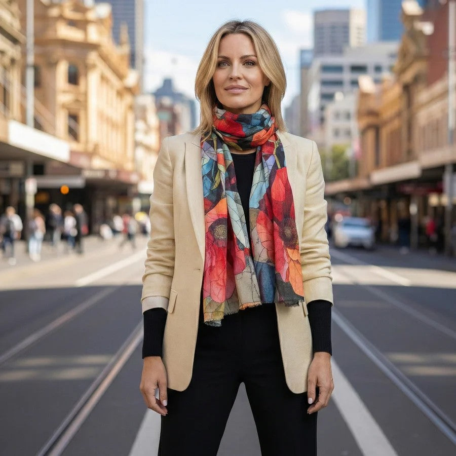 Woman wearing a colorful merino wool scarf and beige blazer on a city street