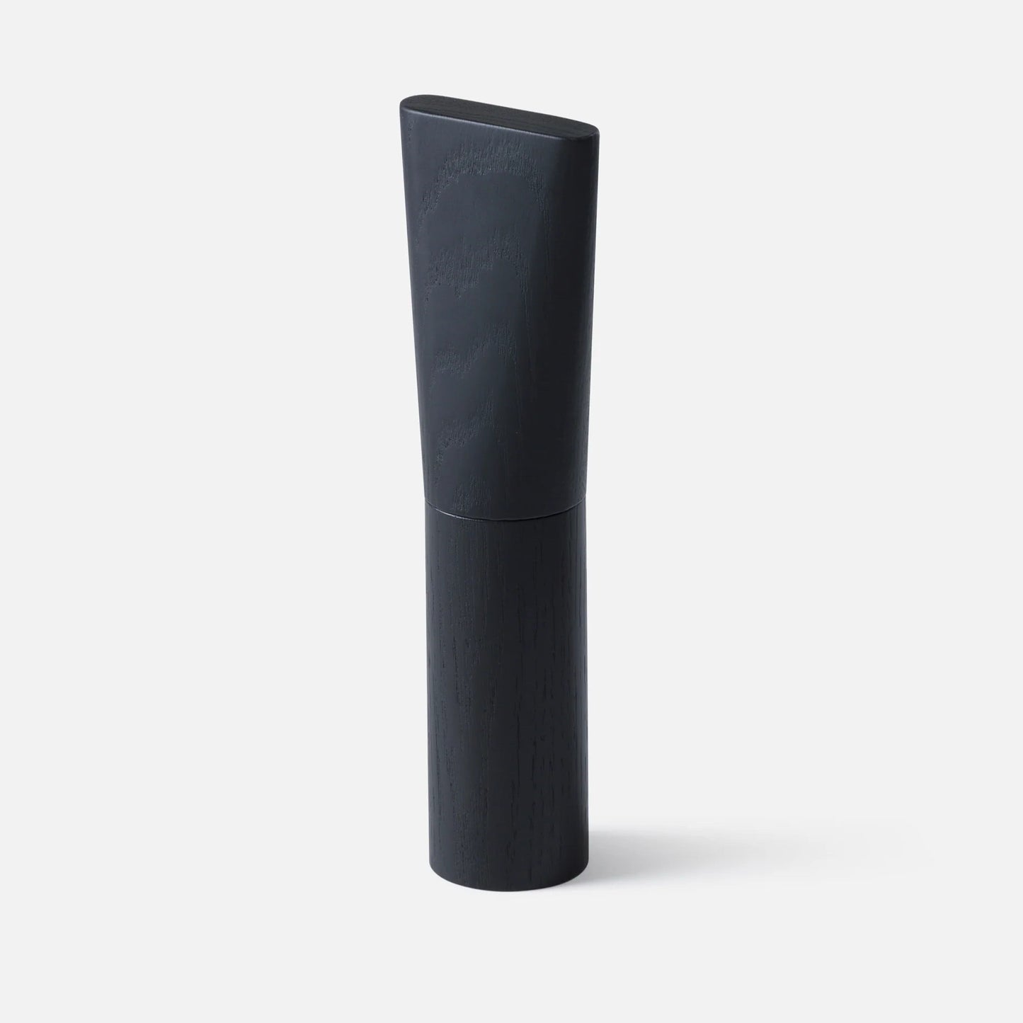A modern, minimalist cylindrical salt/pepper shaker with a dark charcoal gray textured upper cap and a smooth black lower base, standing upright on a light gray background.