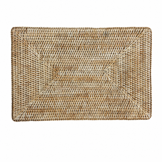 A rectangular rattan woven natural fiber placemat with a textured basketweave pattern 