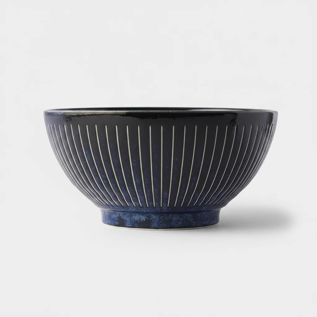 Blue ceramic bowl with ribbed texture on a white background