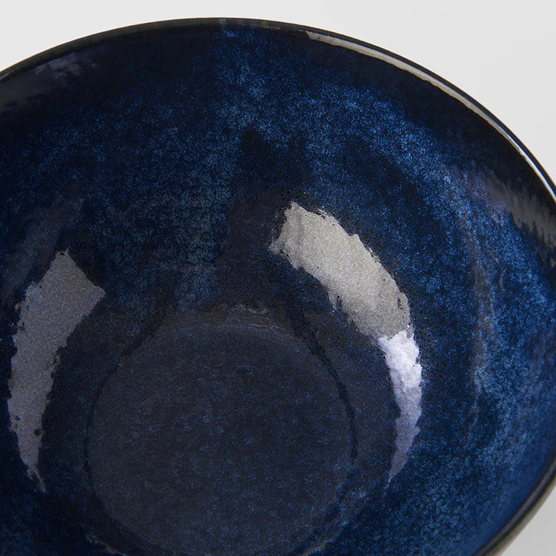 Close-up of a dark blue ceramic bowl with a textured surface.