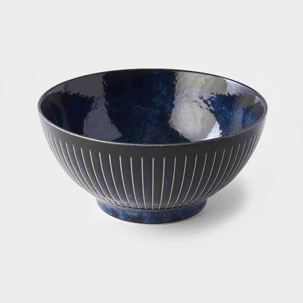 Dark blue ceramic bowl with textured design on a light gray background