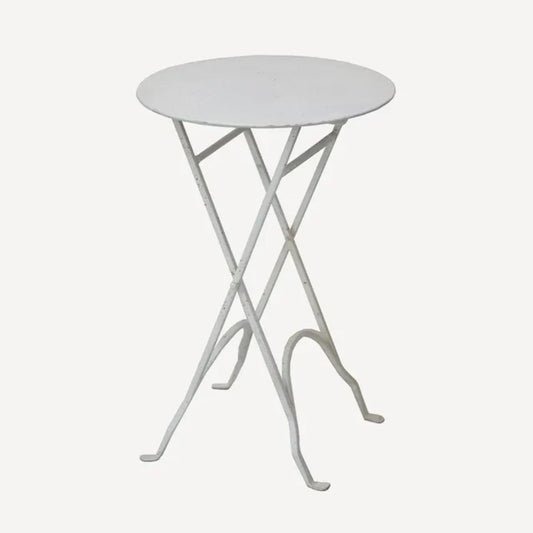 A white, round, narrow iron folding table with a flat surface and slender legs, designed for storage and versatile placement.
