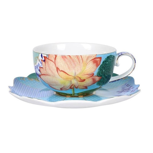 A colorful porcelain cup with a floral pattern and a saucer, featuring gold accents and a blue and white striped base.