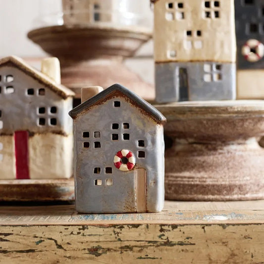 Small ceramic house with a life buoy on a wooden surface
