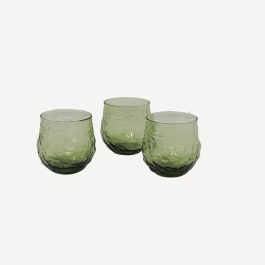 A set of four green glass tumblers with an irregular shape,