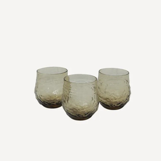 A set of four brown glass tumblers with an irregular, organic shape,
