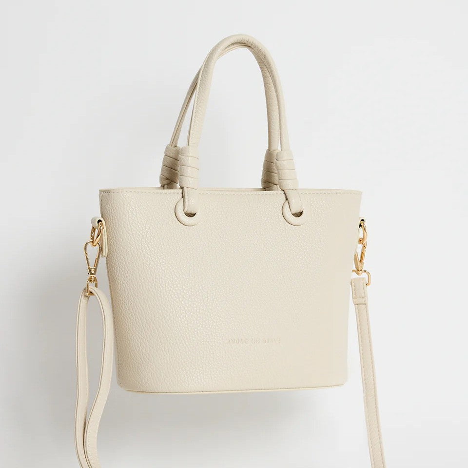 Beige handbag with a shoulder strap on a light gray background