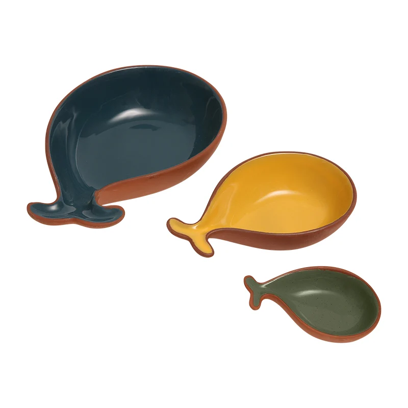 Three terracotta bowls shaped like fish tails in blue, yellow, and green
