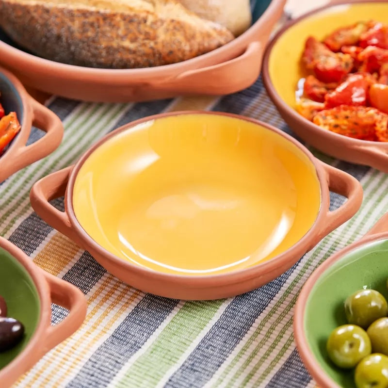 A yellow glazed terracotta serving bowl with terracotta-colored handles,