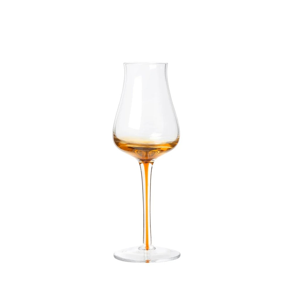 Wine glass with amber liquid on a white background
