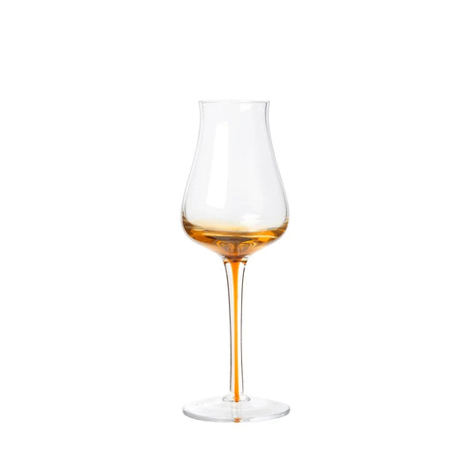 Wine glass with amber liquid on a white background