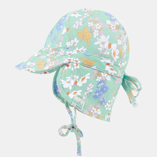 A baby swim cap with a floral pattern in green, orange, and white colors, featuring a flap brim and adjustable head tie.