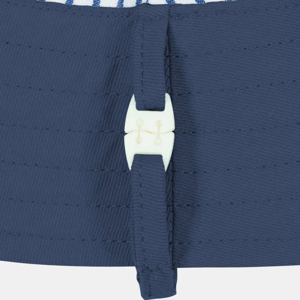 Close-up of a navy blue sun hat with a white  release clasp 