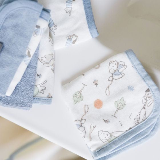 Set of baby toweling wash cloths with illustrations on a light background