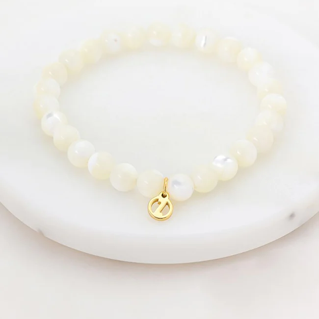 white mother of Pearl bracelet with a gold charm
