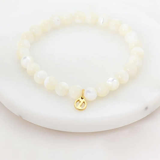 white mother of Pearl bracelet with a gold charm