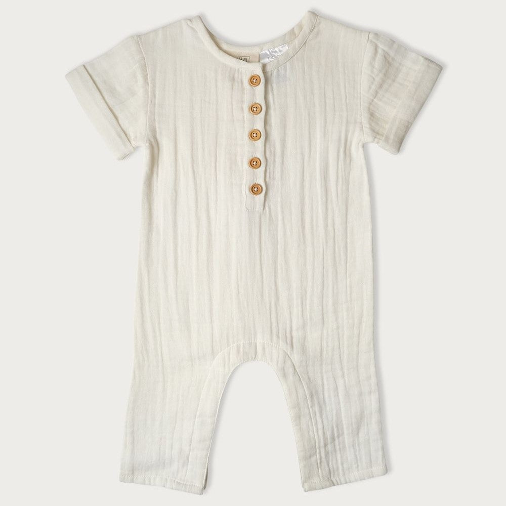 A beige-colored baby romper with short sleeves, wooden buttons down the center, and snap domes at the legs.