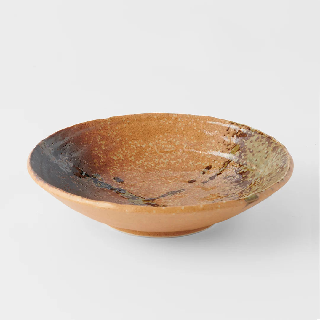 A shallow ceramic bowl with a speckled, glossy glaze in warm brown, tan, and muted green tones,