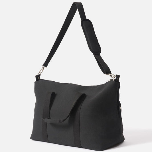 A black canvas weekender bag with a shoulder strap and a zippered closure.

