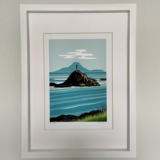A framed artwork featuring a coastal scene with a lighthouse