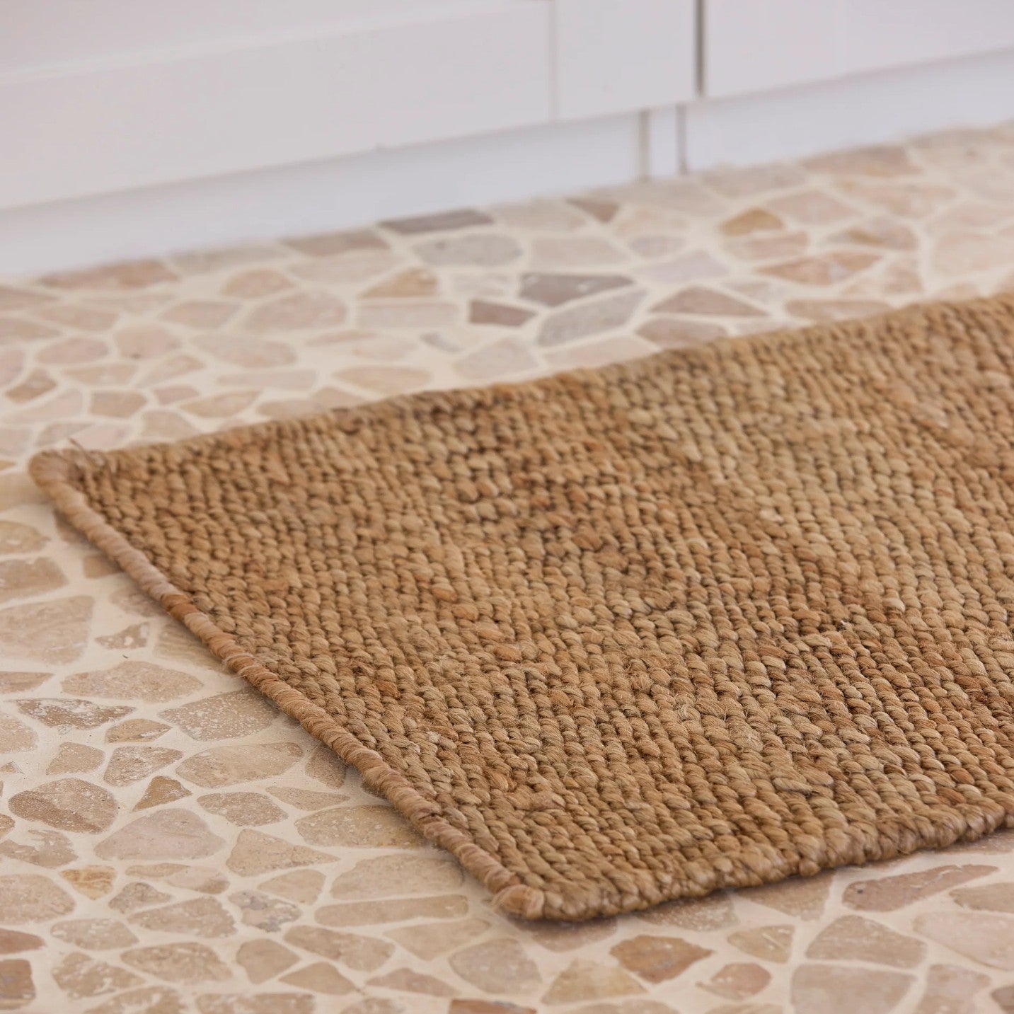Brown woven mat on a stone-tiled floor