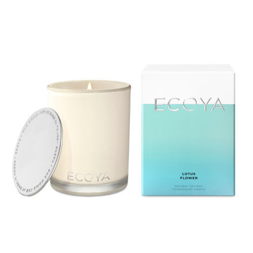 A beige Ecoya Lotus Flower Madison candle in a glass jar with a silver lid, accompanied by a white and blue box with the Ecoya brand and product name.